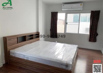 Modern bedroom interior with large bed and air conditioning unit