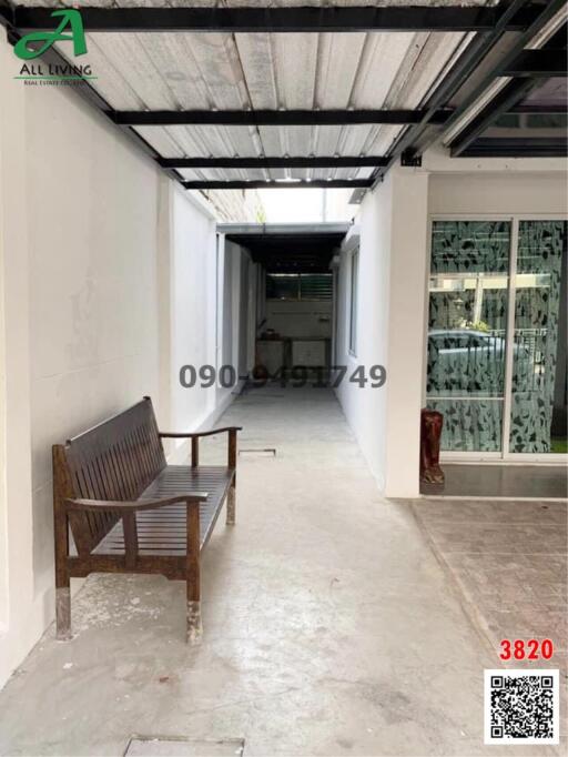 Spacious corridor with tiled flooring, high ceiling, and a wooden bench