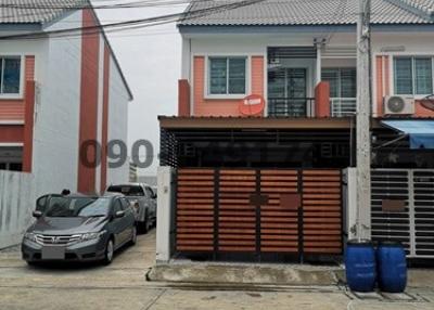 Two-story residential building with a gated garage area