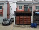 Two-story residential building with a gated garage area