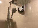 Modern shower head with handheld attachment in a tiled bathroom