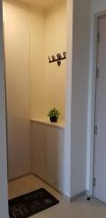 Minimalist entryway with decorative wall hooks and a built-in storage cabinet