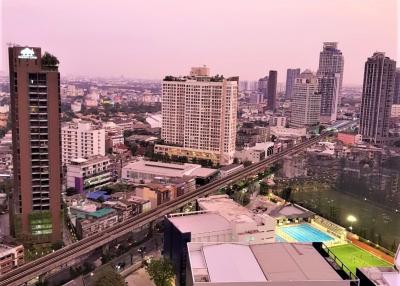 Aerial view of a vibrant city at dusk with buildings and infrastructure