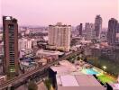 Aerial view of a vibrant city at dusk with buildings and infrastructure