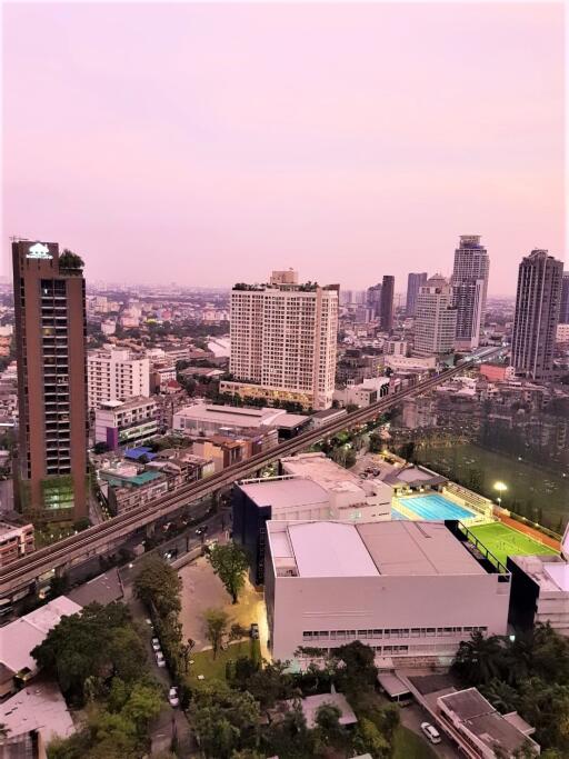 Aerial view of a vibrant city at dusk with buildings and infrastructure