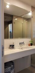 Modern bathroom interior with a well-lit vanity area and mirrored cabinets