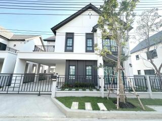 Modern two-story house with balcony and garden area