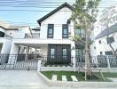 Modern two-story house with balcony and garden area