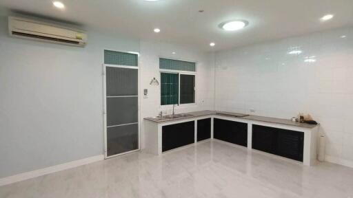 Modern kitchen with white countertops and ceramic tile flooring