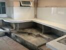 Unfinished kitchen with bare concrete structures and missing appliances