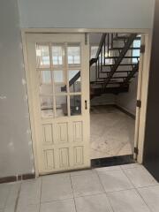 Interior view of a home showing a wooden door and staircase