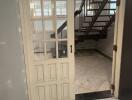 Interior view of a home showing a wooden door and staircase