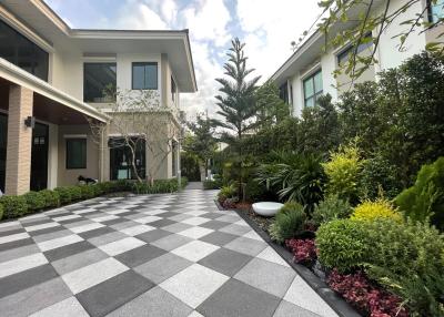 Elegant exterior pathway with checkered tiles leading to modern residential homes