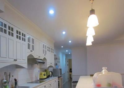 Spacious kitchen with modern lighting and white cabinets