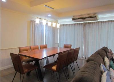 Spacious dining room with a large table, comfortable seating, and ample lighting