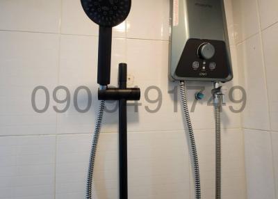 Modern wall-mounted water heater with handheld showerhead in a bathroom