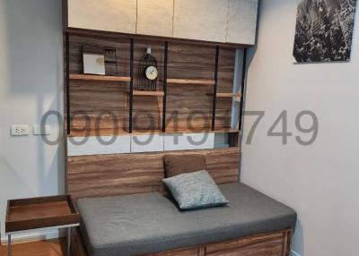 Modern bedroom with built-in shelving and a cozy sitting area