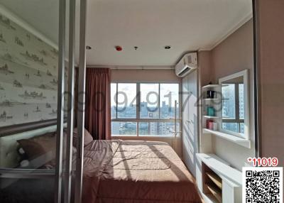 Spacious bedroom with large windows and city view