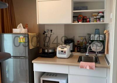 Compact kitchen with modern appliances and white cabinetry