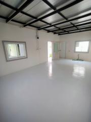 Spacious well-lit empty interior space with white walls and epoxy flooring