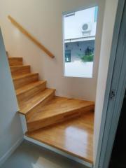 Modern wooden staircase with a white handrail