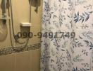 Compact bathroom with floral shower curtain and water heater