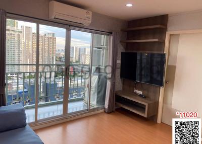 Modern living room with city view, large windows and a flat-screen TV