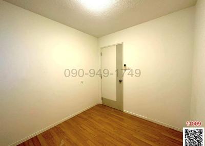 Empty bedroom with wooden floor and white walls