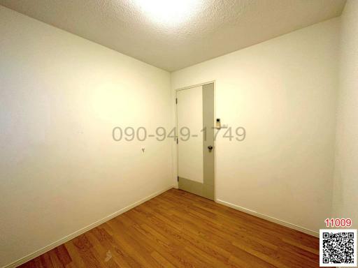 Empty bedroom with wooden floor and white walls