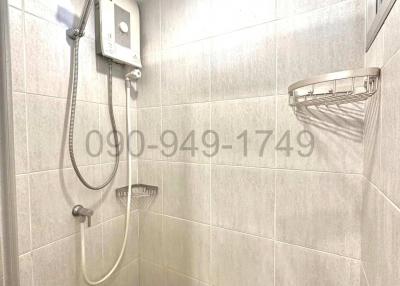 Modern tiled bathroom with shower and water heater
