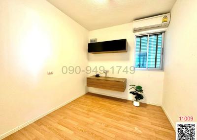 Minimalist bedroom with wooden flooring and air conditioning unit