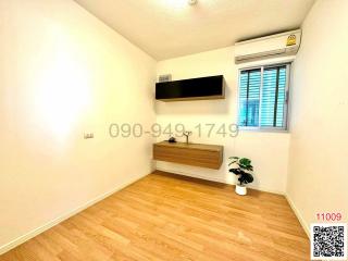 Minimalist bedroom with wooden flooring and air conditioning unit