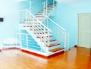 Bright interior with staircase, wooden flooring, and blue walls