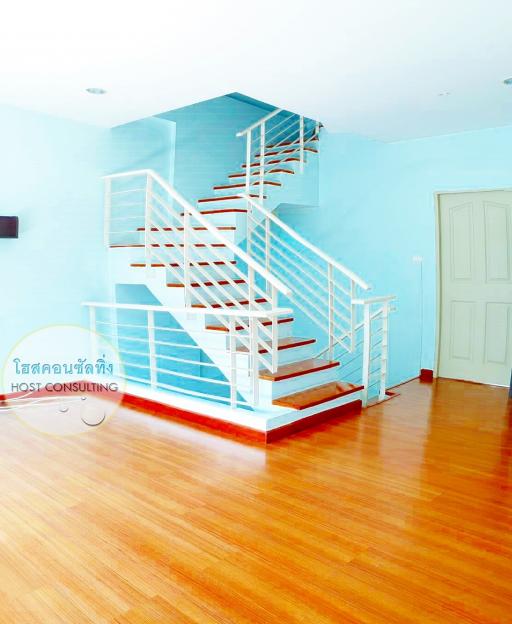 Bright interior with staircase, wooden flooring, and blue walls
