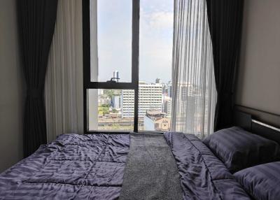 Cozy bedroom with a large window overlooking the city