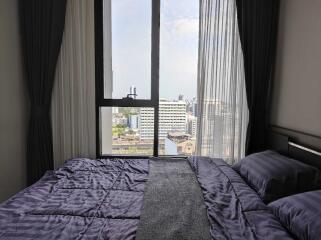 Cozy bedroom with a large window overlooking the city