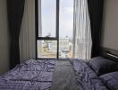 Cozy bedroom with a large window overlooking the city