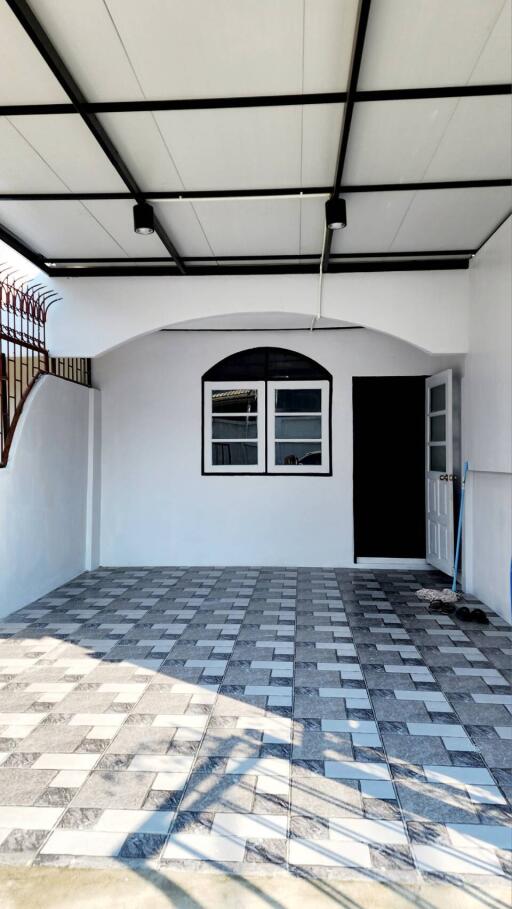 Modern residential garage interior with tiled floor and ample natural light
