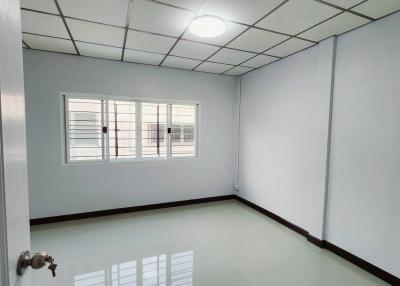 Bright and spacious empty bedroom with reflective flooring and large window