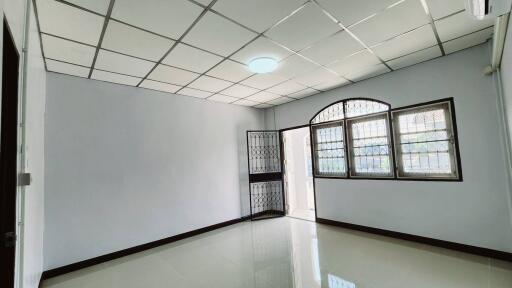 Spacious empty room with glossy tiled flooring and large windows