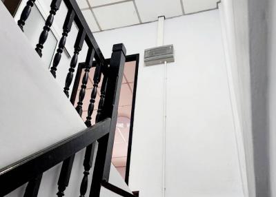 Modern staircase in a residential property with black banisters and white walls