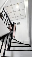 Modern staircase in a residential property with black banisters and white walls