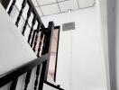 Modern staircase in a residential property with black banisters and white walls