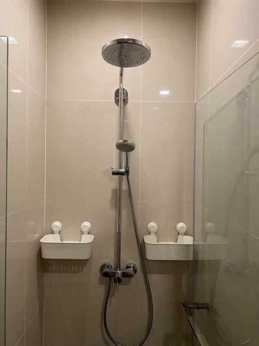 Modern bathroom with wall-mounted shower and glass door