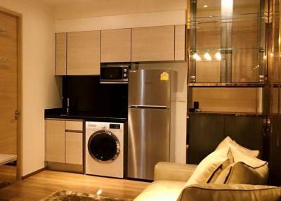 Modern kitchen with stainless steel appliances and adjacent living area