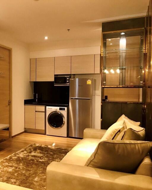 Modern kitchen with stainless steel appliances and adjacent living area