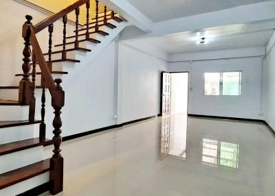 Spacious interior view of a building with staircase leading to upper floor