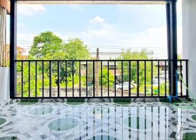 Spacious balcony with decorative floor tiles and a garden view