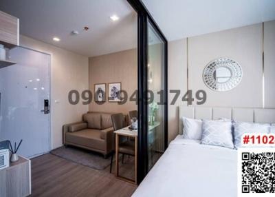 Modern bedroom with a comfortable bed, a cozy sitting area, and glass sliding doors