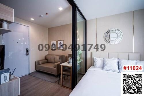 Modern bedroom with a comfortable bed, a cozy sitting area, and glass sliding doors